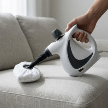 The Sanora steam cleaner fitted with its microfiber bonnet, resting on a linen sofa cushion